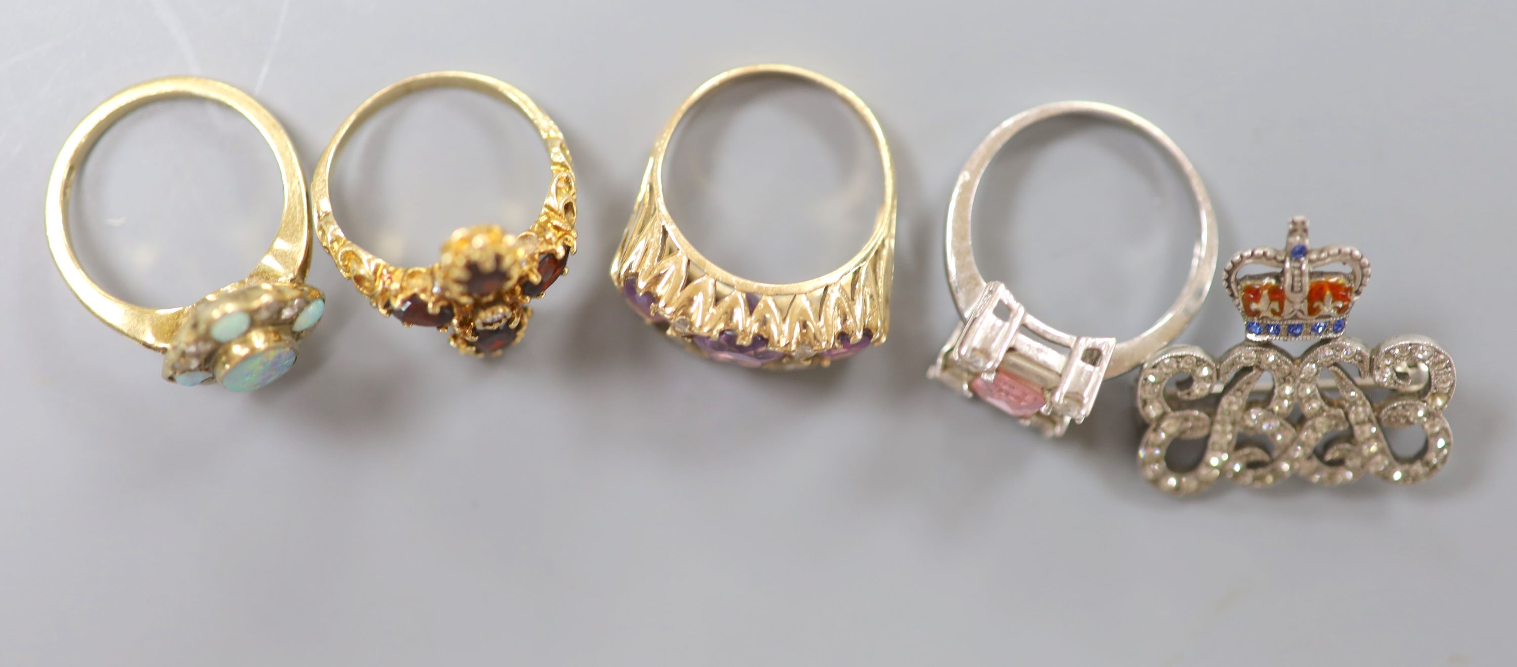 Four assorted modern 9ct gold and gem set dress rings, including amethyst and white opal, gross 16.2 grams and a paste set white metal brooch